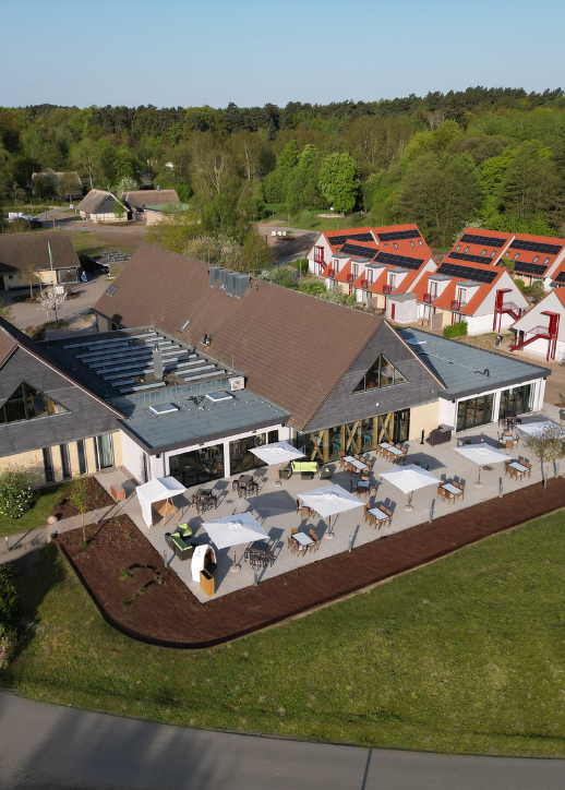 Luftaufnahme eines Resorts mit einem einladenden Schwimmbad inmitten üppiger Landschaft.