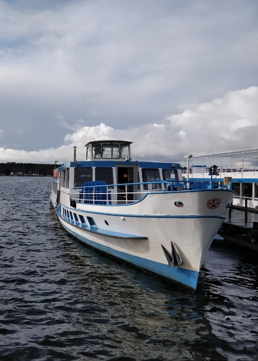 Ein Boot schwimmt ruhig auf dem Wasser, umgeben von sanften Wellen und einem klaren Himmel.