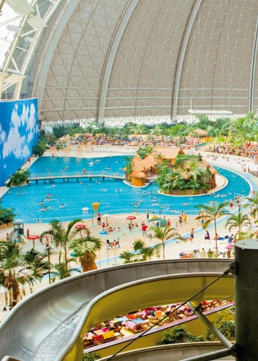 Ein Innenwasserpark mit Rutschen und einem großen Pool, ideal für Familien und Wasserspaß.