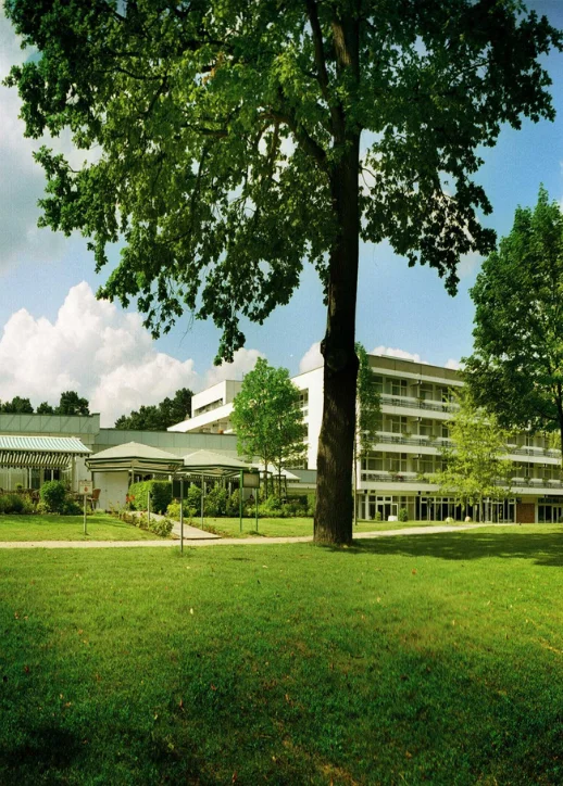 Ein imposantes Gebäude, eingebettet in eine grüne Landschaft mit Bäumen und Wiese am Müggelsee.