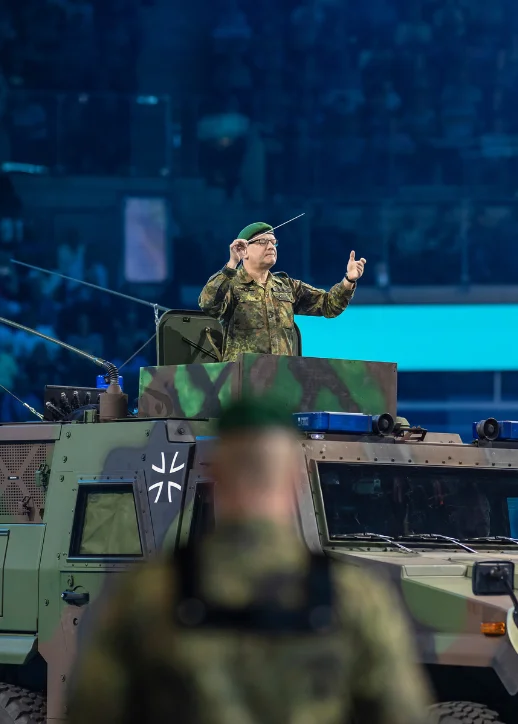 Ein Soldat dirigiert aus einem Militärfahrzeug.