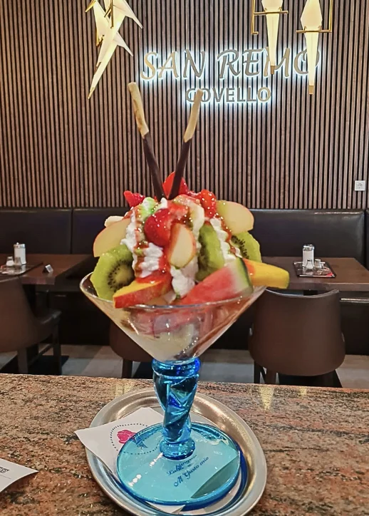 Ein bunter Eisbecher von Obst geschmückt auf einem Tisch in einem gemütlichen Restaurant