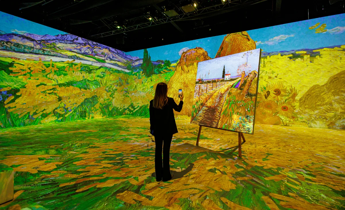 Eine Frau arbeitet an einem großen Bildschirm in der Van Gogh immersiven Ausstellung.