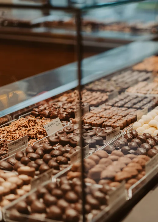 Vitrine mit einer Auswahl an handgefertigten Schokoladen und Pralinen von Walter Confiserie in Berlin, ideal für die Adventszeit.