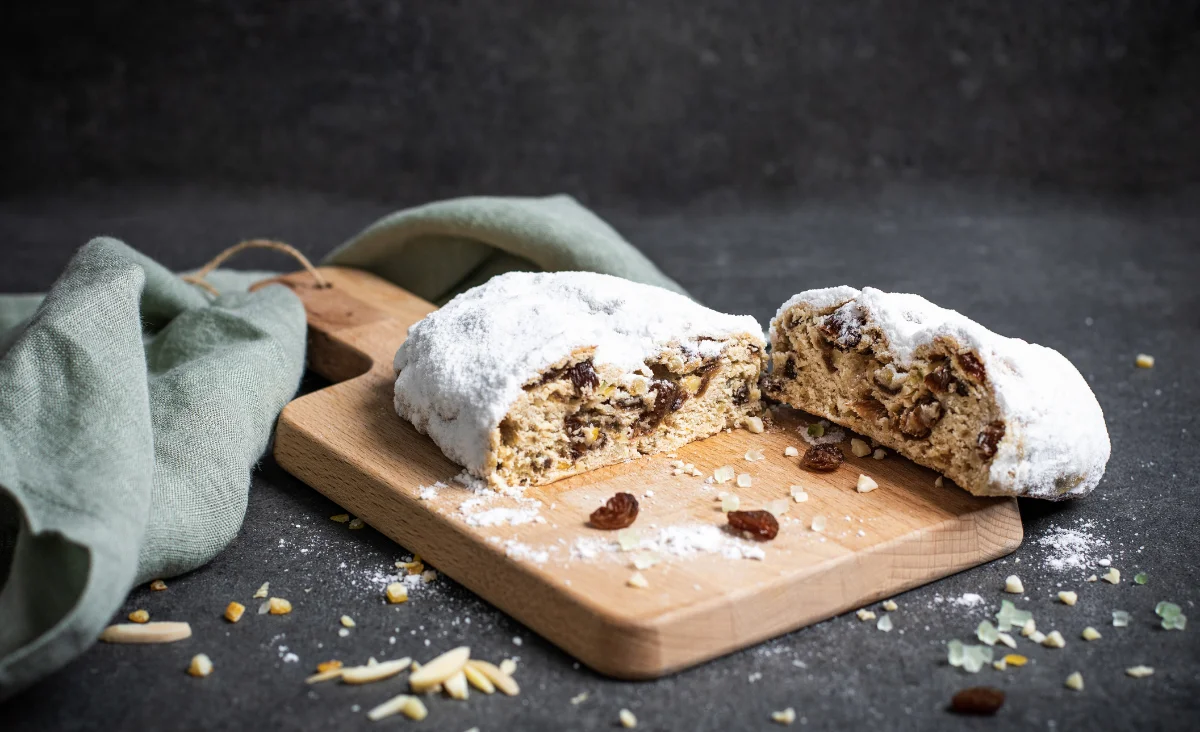 Dresdner Christstollen von Stollenbäckerei Krause, dekoriert mit Nüssen und Walnüssen auf einem Tisch.