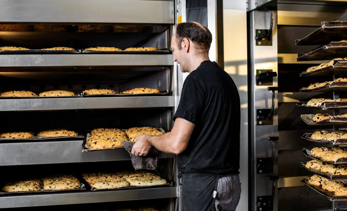Ein Mann legt frisch gebackene Stollen in den Ofen in der Stollenbäckerei Krause in Dresden.