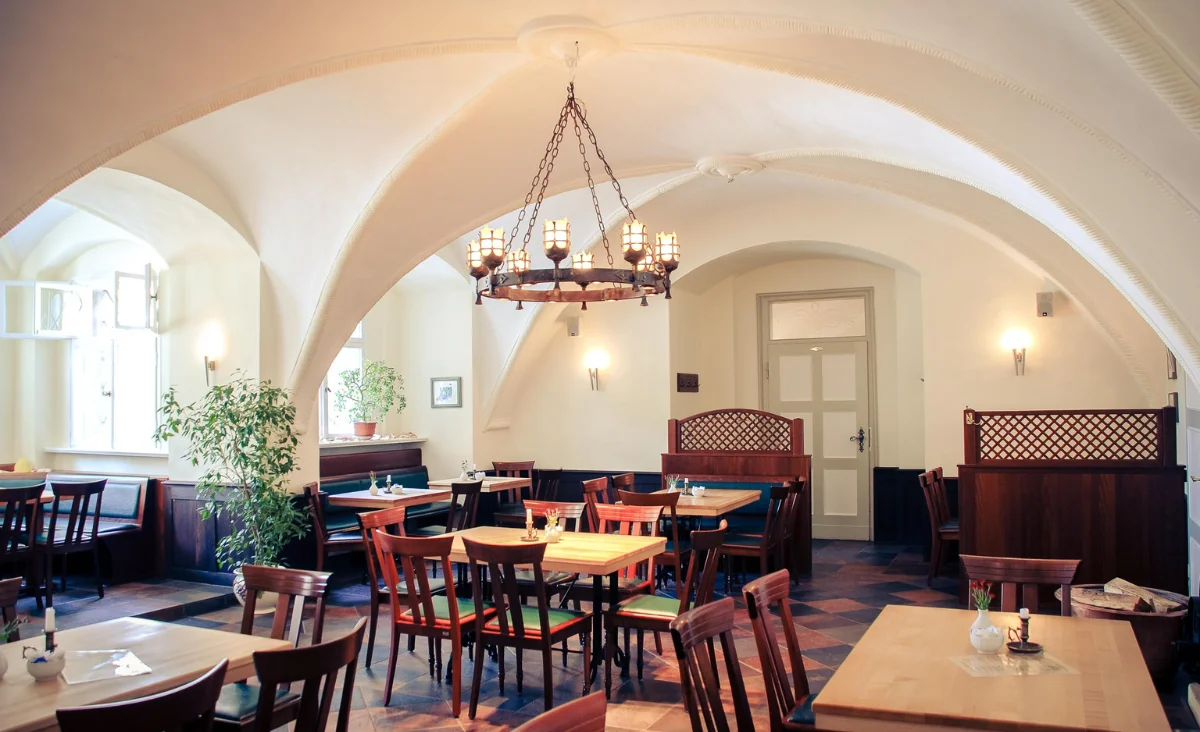 Braune Tische im Wasserschloss Mellenthin auf Usedom, umgeben von historischem Ambiente.