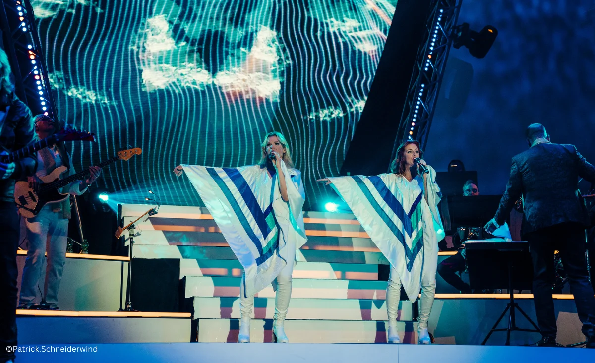 Auf der Bühne stehen zwei Frauen in weißen und blauen Outfits bei ABBAMANIA THE SHOW in der Uber Arena, Berlin.