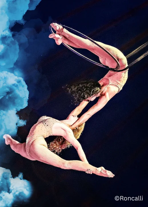 Zwei Personen führen im Roncalli Weihnachtscircus Berlin Luftakrobatik in einer großen Arena auf.