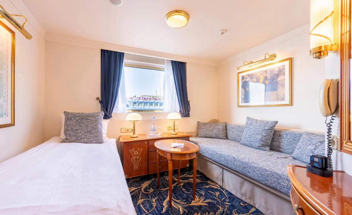 Foto einer Kabine an Bord der MS Thurgau Chopin mit einem Bett und einer Couch, ideal für eine romantische 8-tägige Flusskreuzfahrt für zwei.