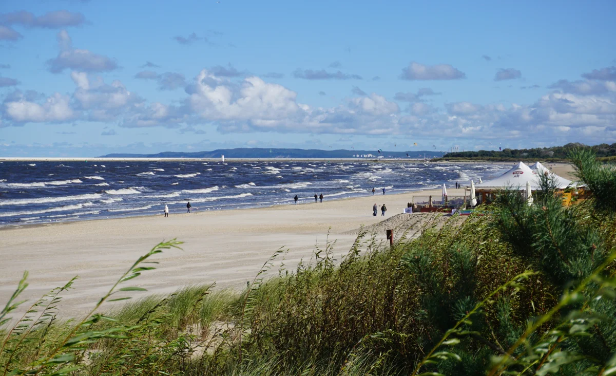 Ein sonniger Sandstrand an der Ostsee, ideal für eine entspannte Flusskreuzfahrt für zwei Personen.