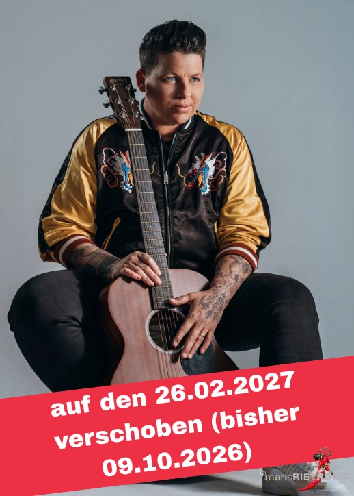 Kerstin Ott auf einem Stuhl mit akustischer Gitarre, Teil von SCHLAGERNACHT'26 mit Kerstin Ott.