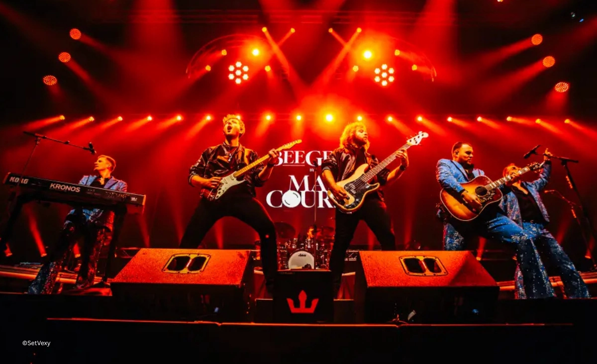 Bee Gees by MainCourse Band performt energetisch mit Gitarren und Keyboard in rotem Bühnenlicht