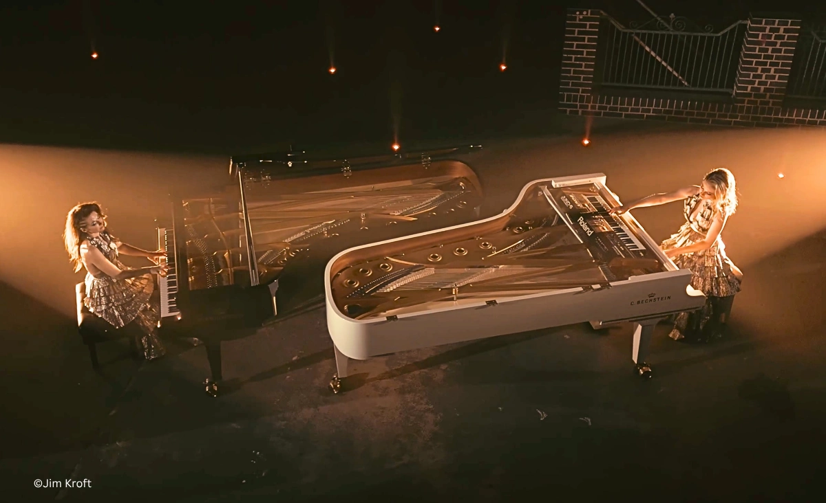 Queenz of Piano Pianistinnen an zwei Flügeln im Panoramaformat auf stimmungsvoll beleuchteter Bühne.